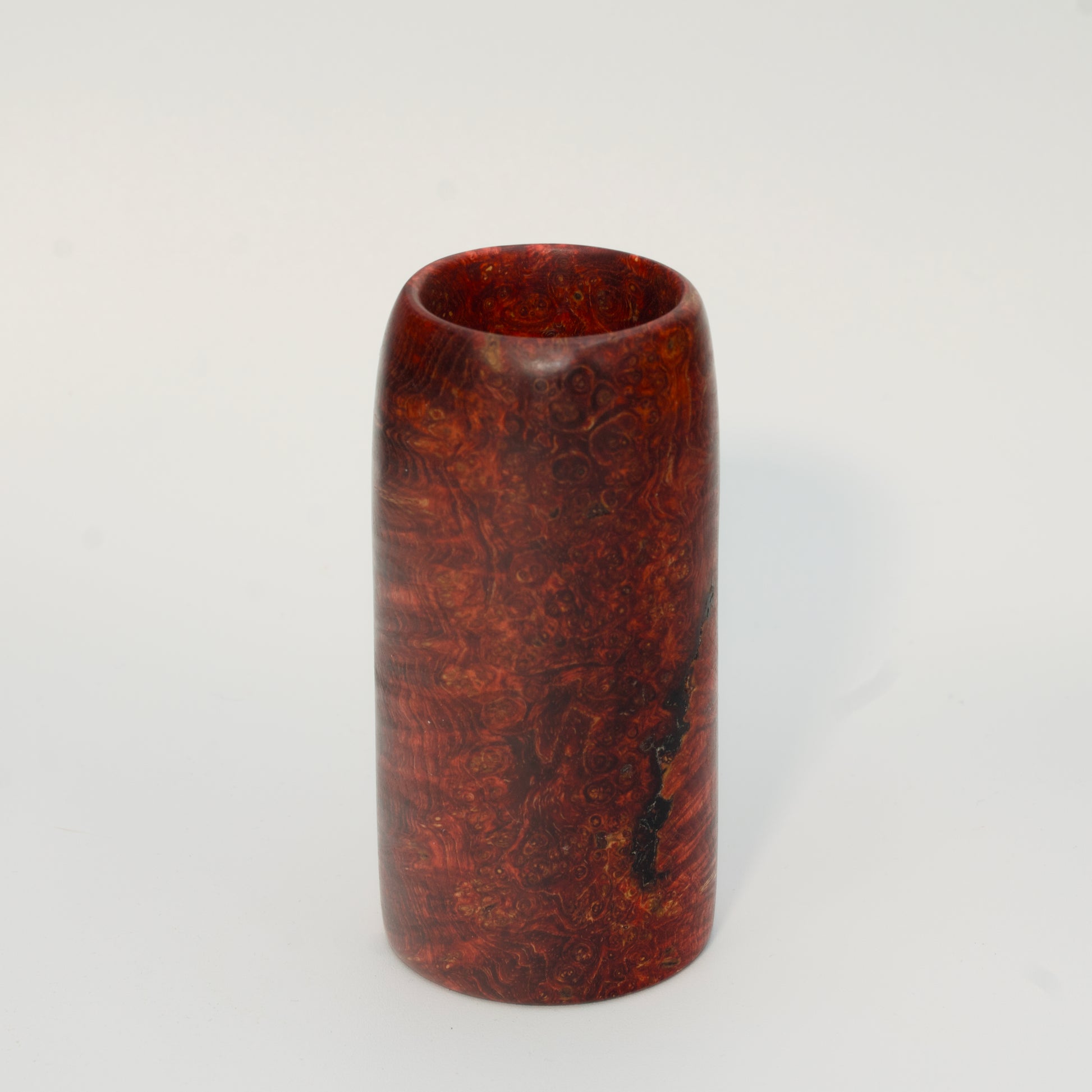 Red amboyna burl shot glass against white background