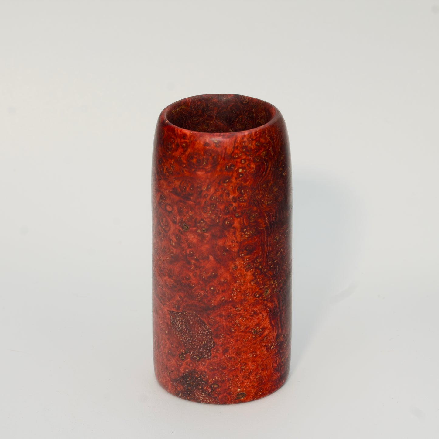 Red amboyna burl shot glass against white background