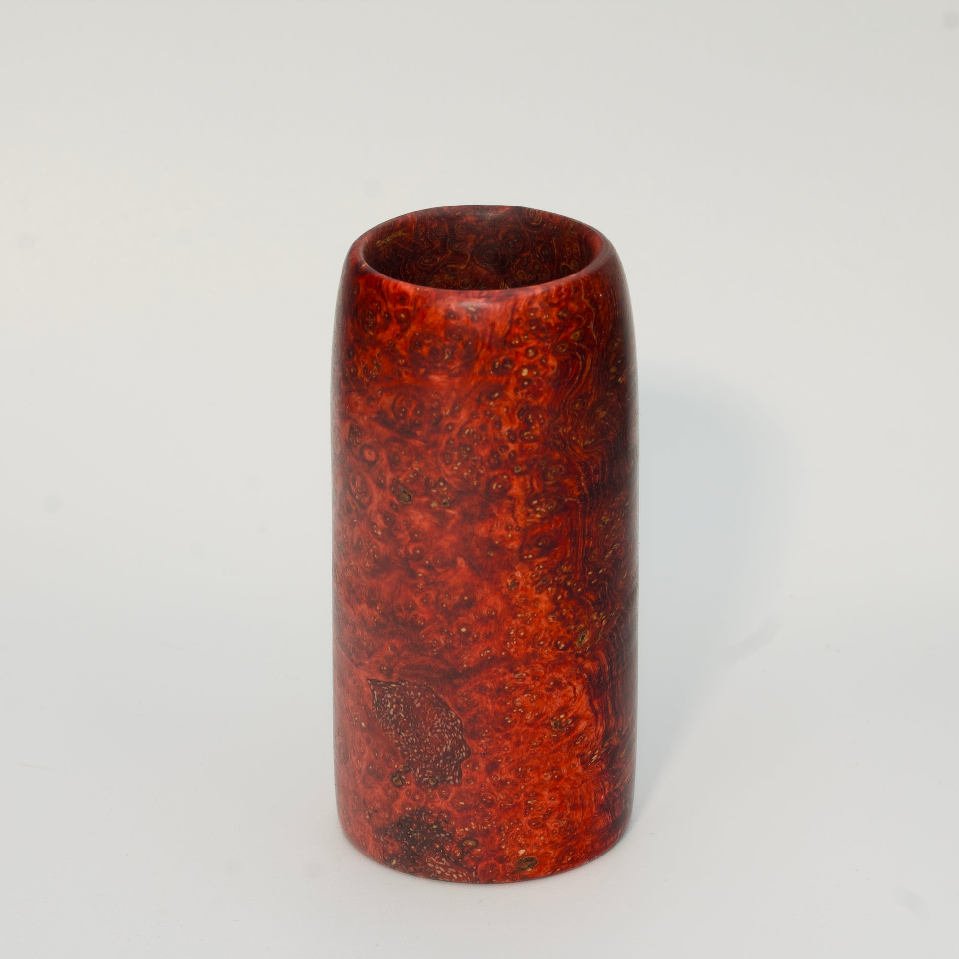 Red amboyna burl shot glass against white background