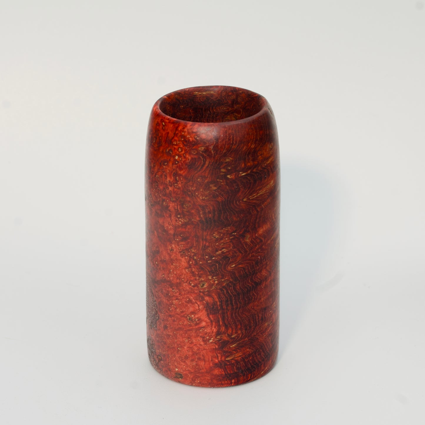 Red amboyna burl shot glass against white background