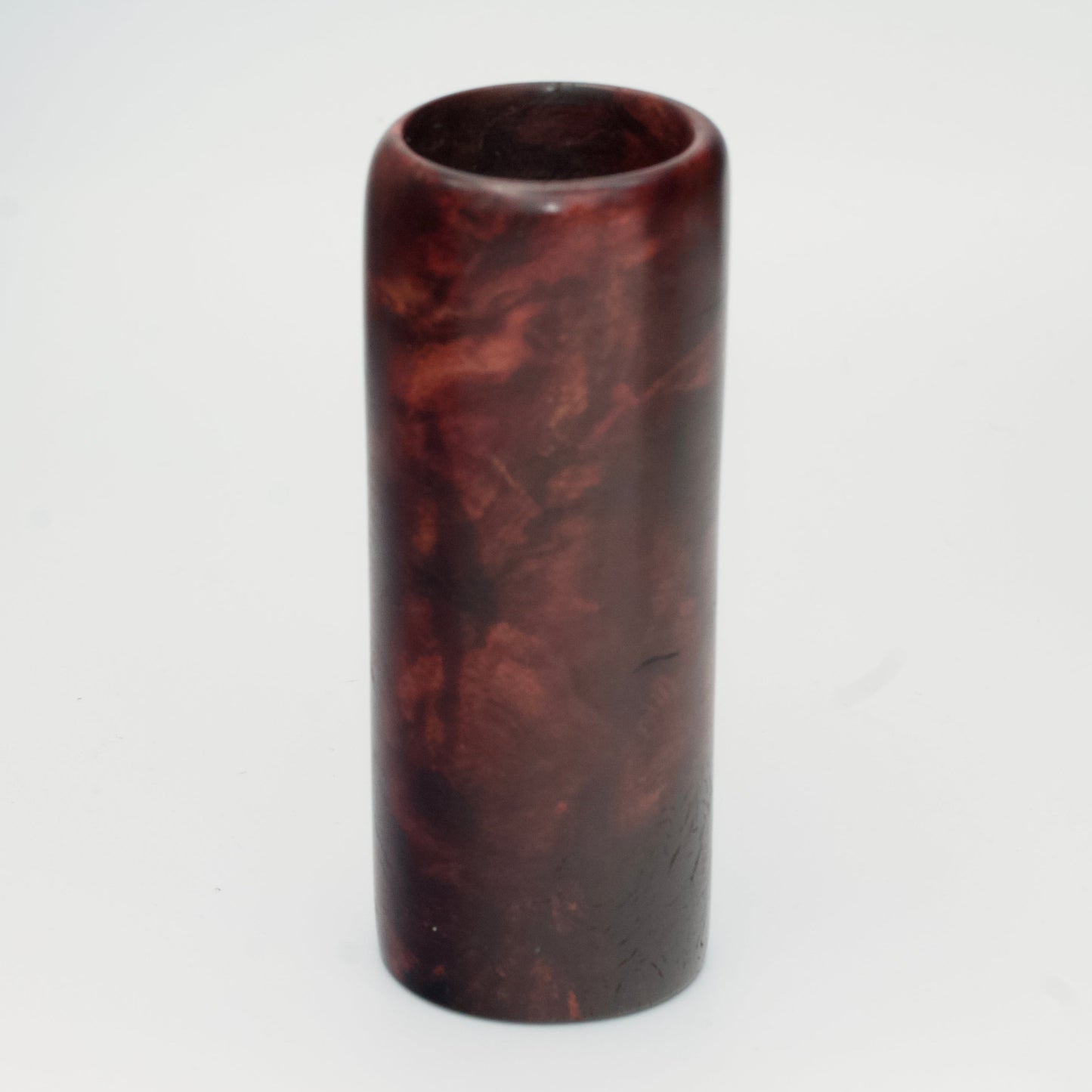 Purple colored maple burl shot glass against white background