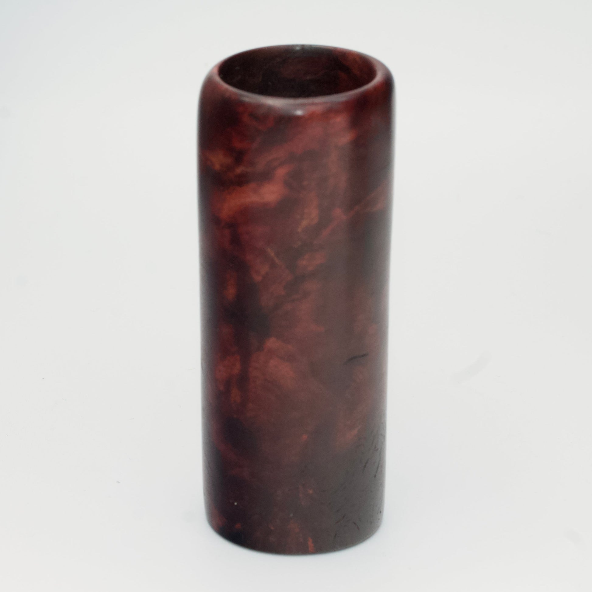 Purple colored maple burl shot glass against white background