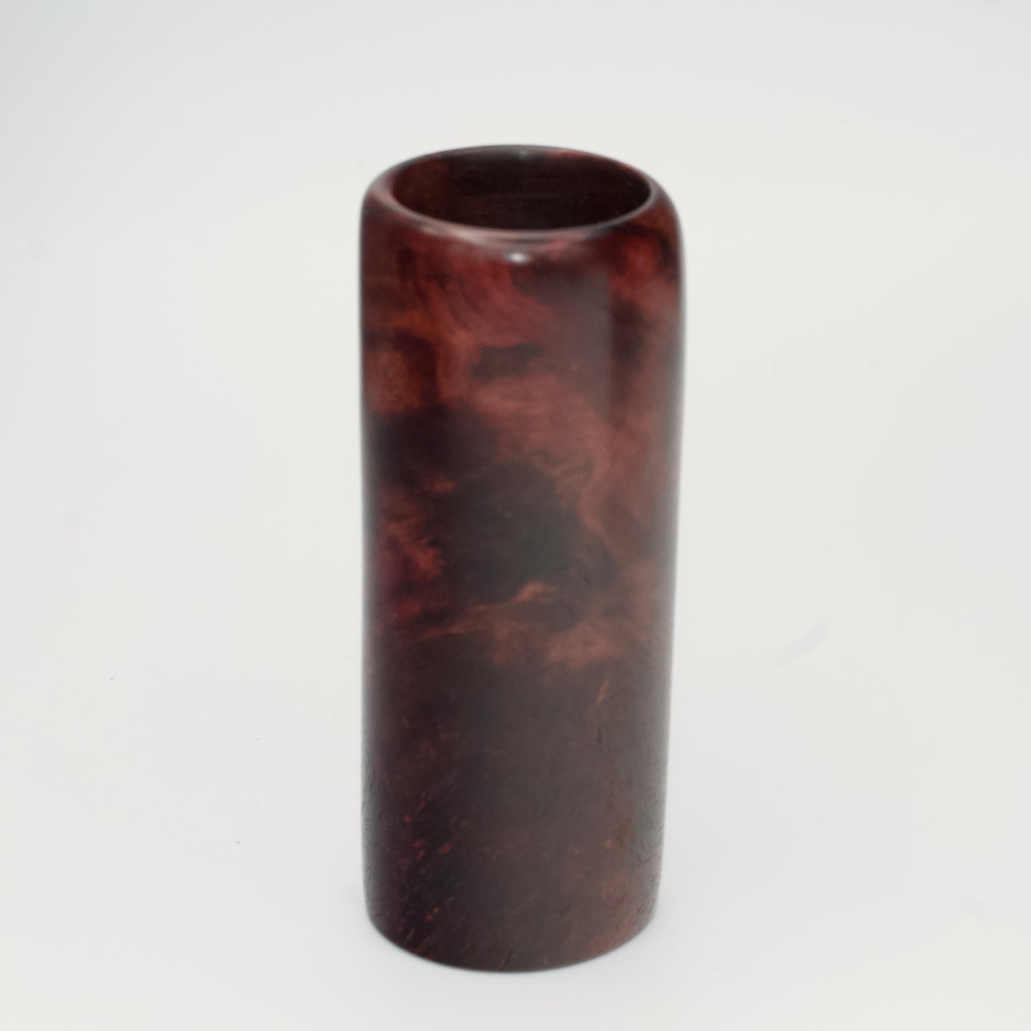 Purple colored maple burl shot glass against white background