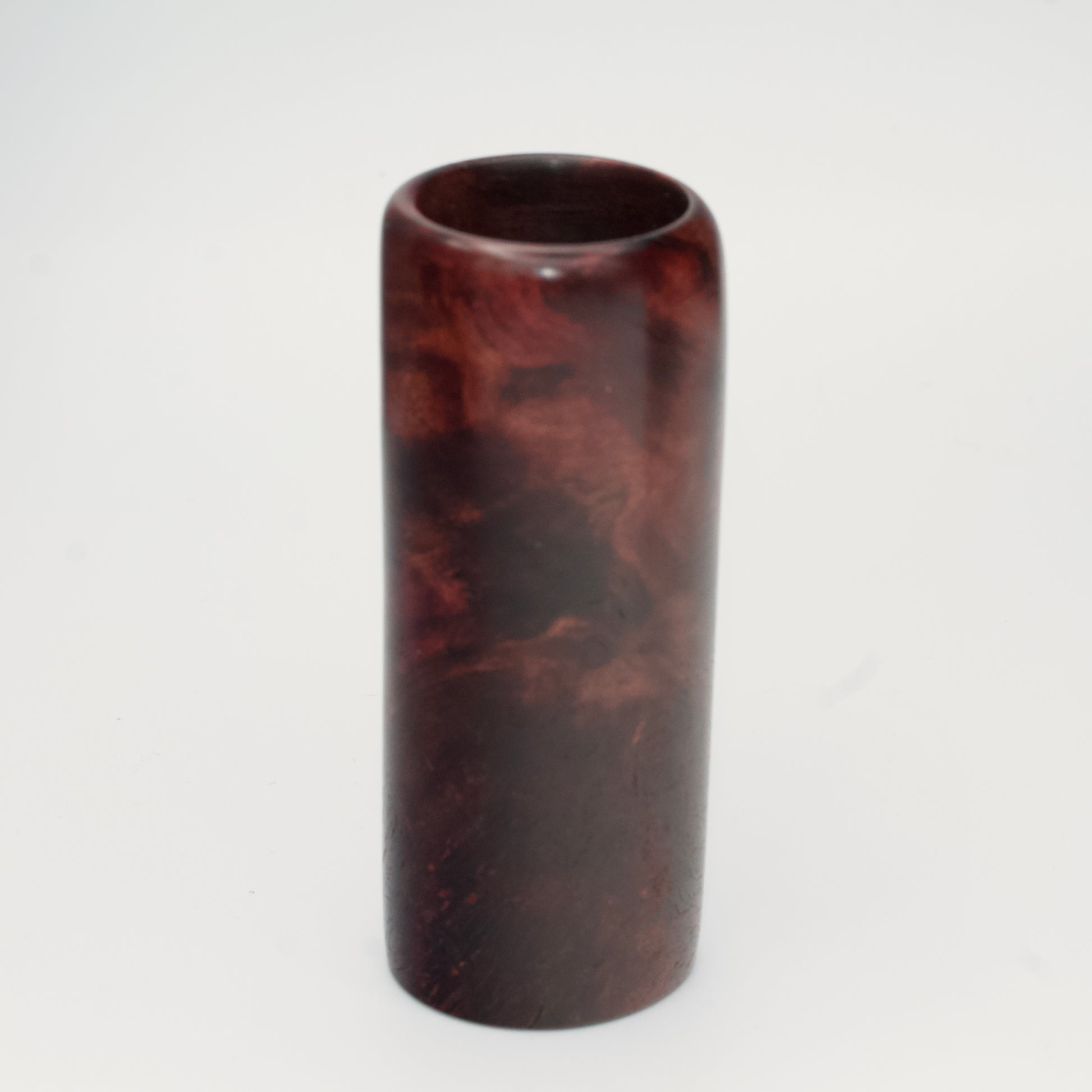 Purple colored maple burl shot glass against white background