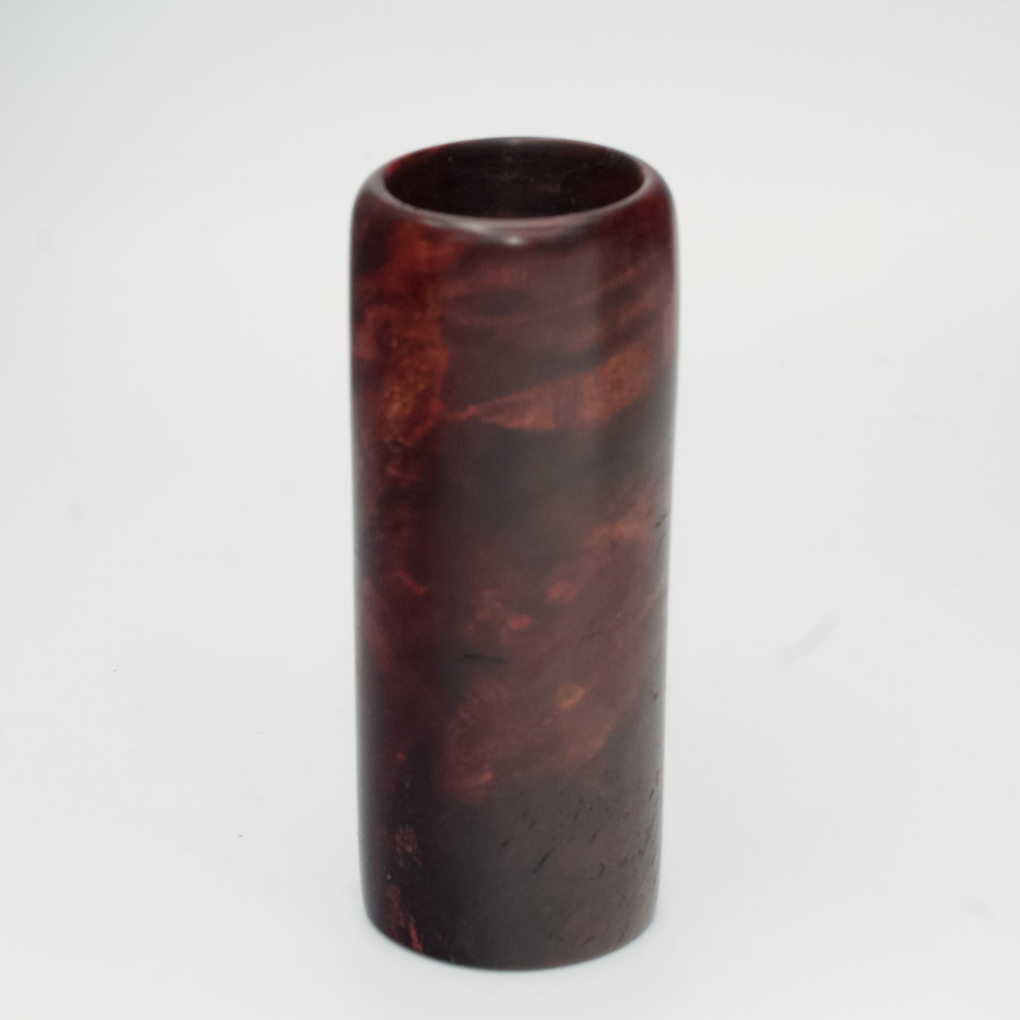 Purple colored maple burl shot glass against white background