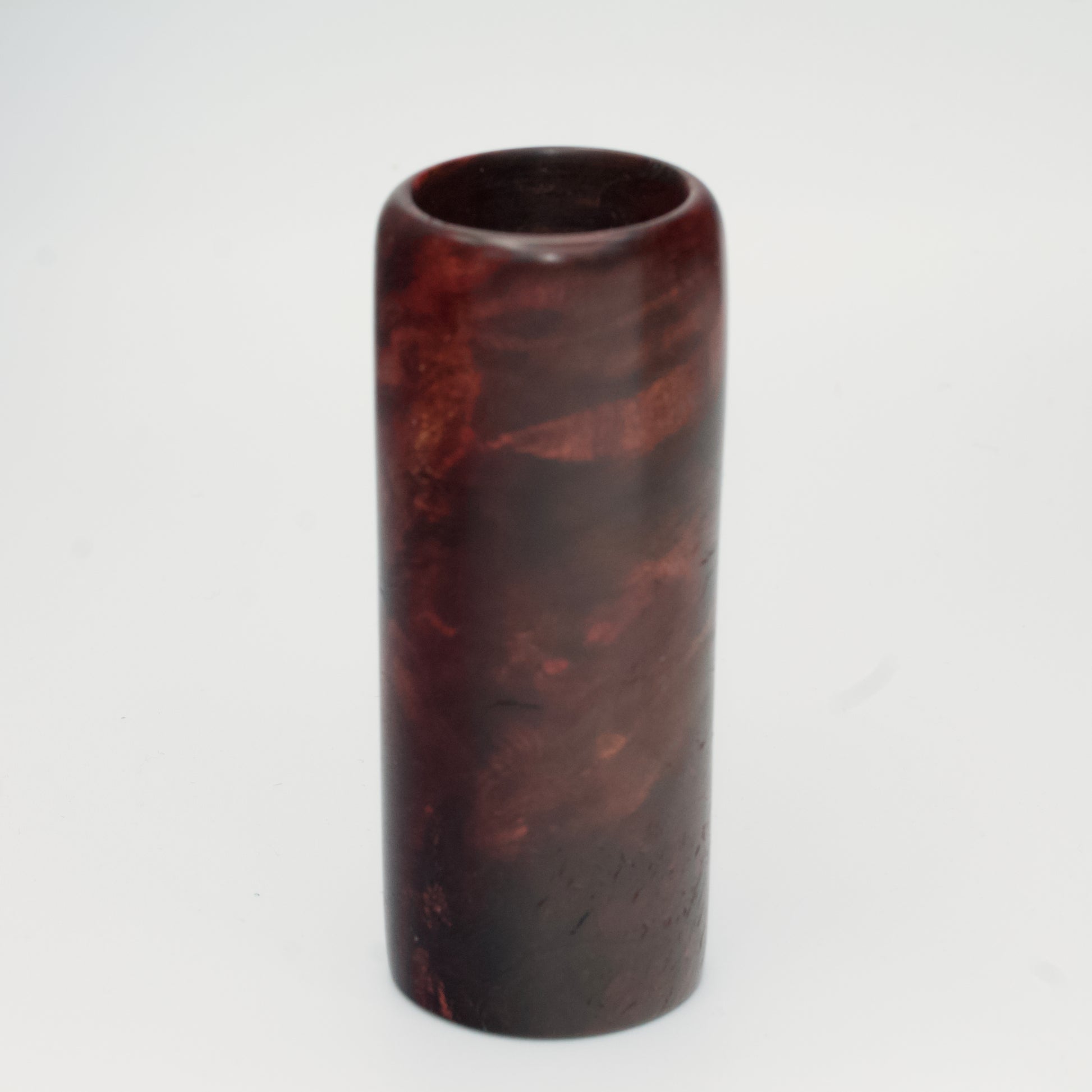 Purple colored maple burl shot glass against white background