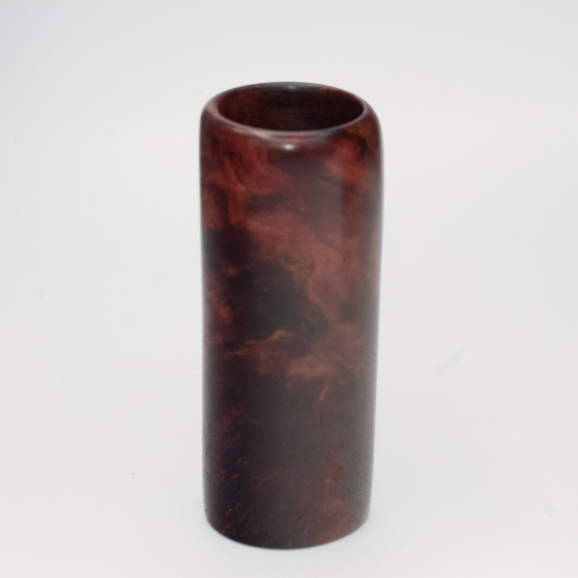 Purple colored maple burl shot glass against white background