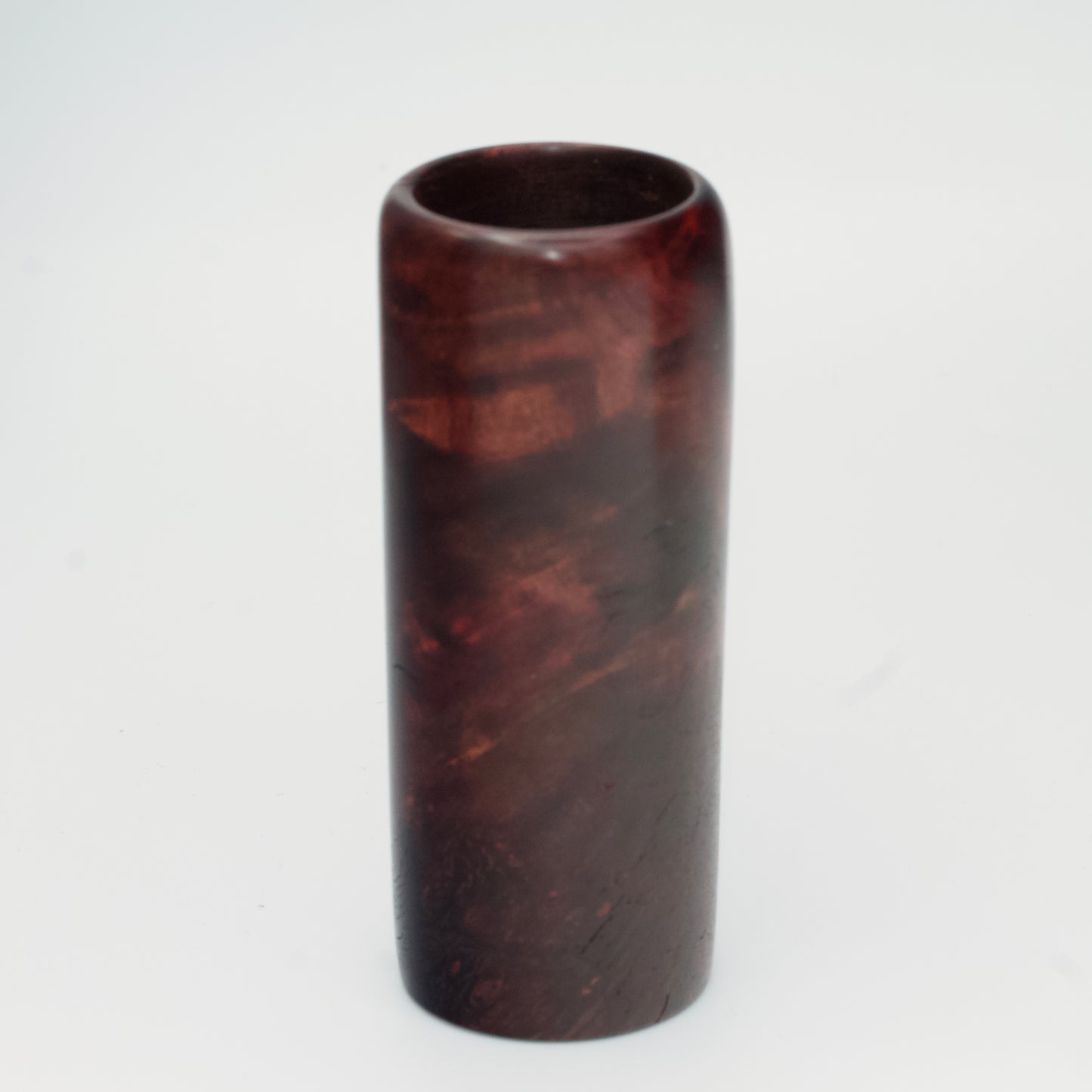 Purple colored maple burl shot glass against white background