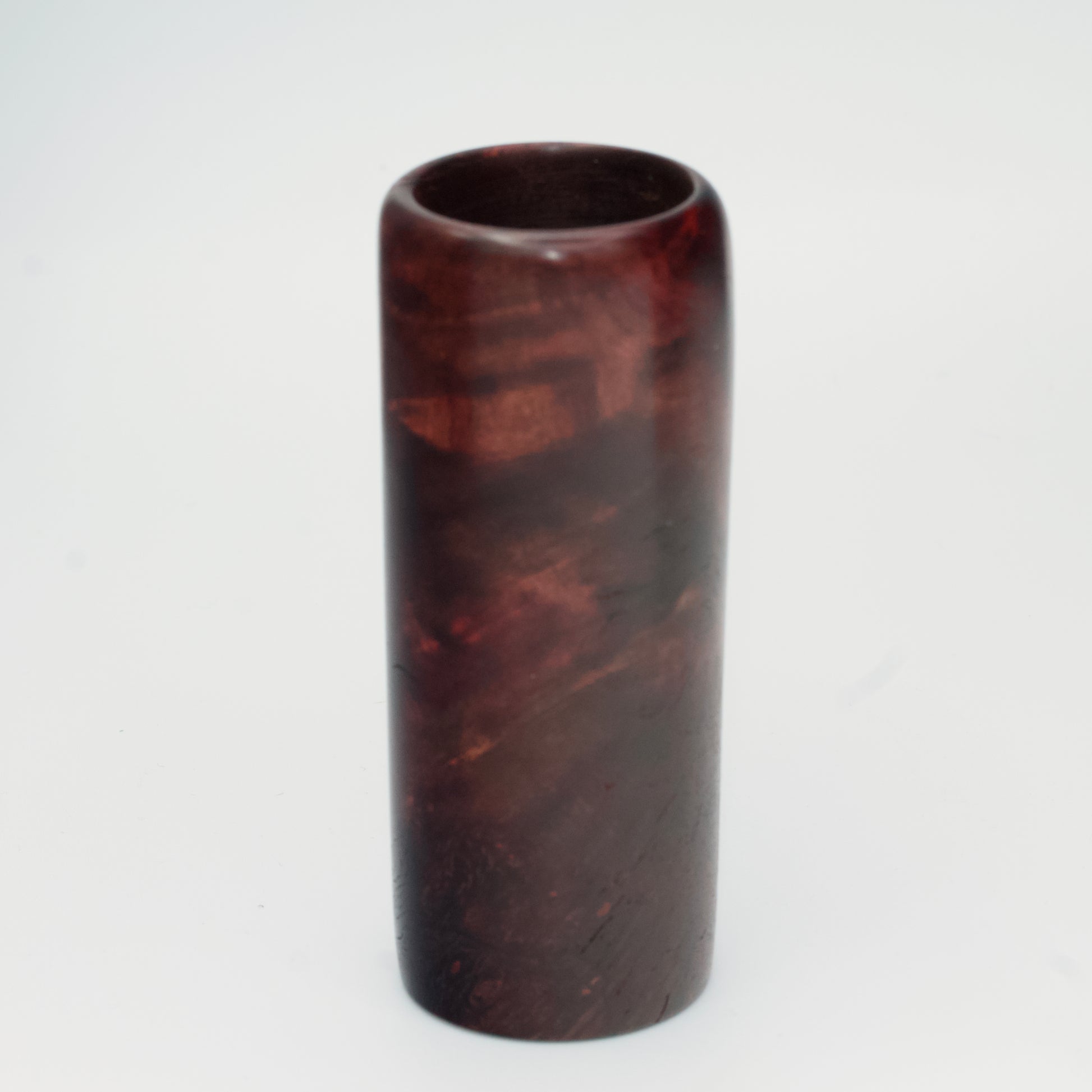 Purple colored maple burl shot glass against white background