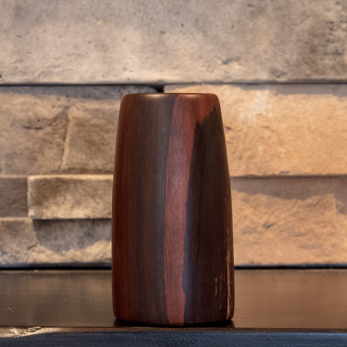 The First Lesson shot glass with a narrow reddish vertical stripe between dark grain bands