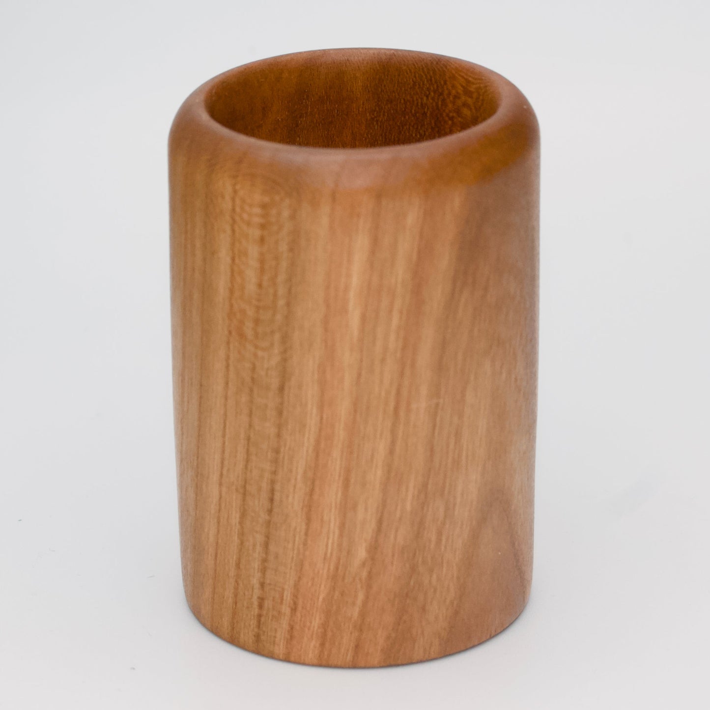 Cherry wood shot glass against white background