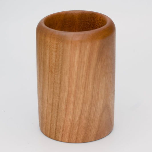 Cherry wood shot glass against white background