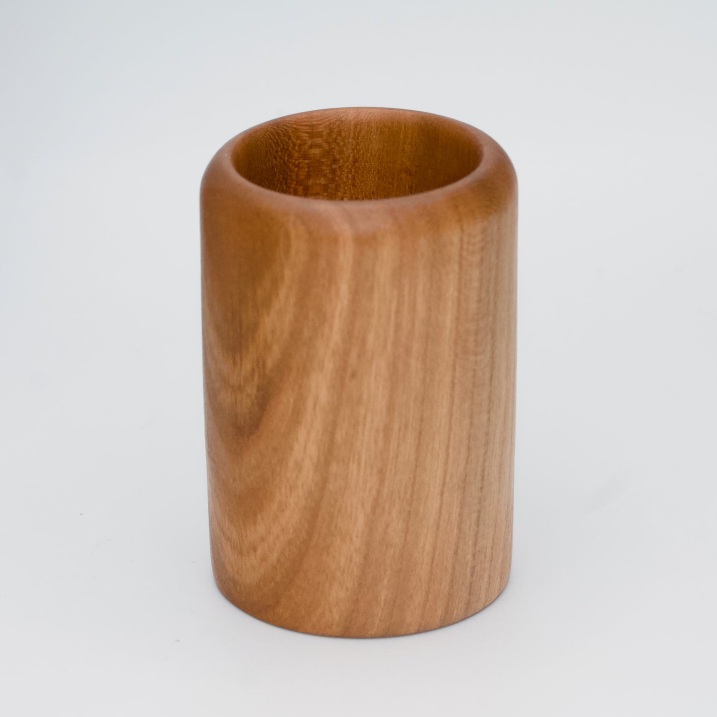 Cherry wood shot glass against white background