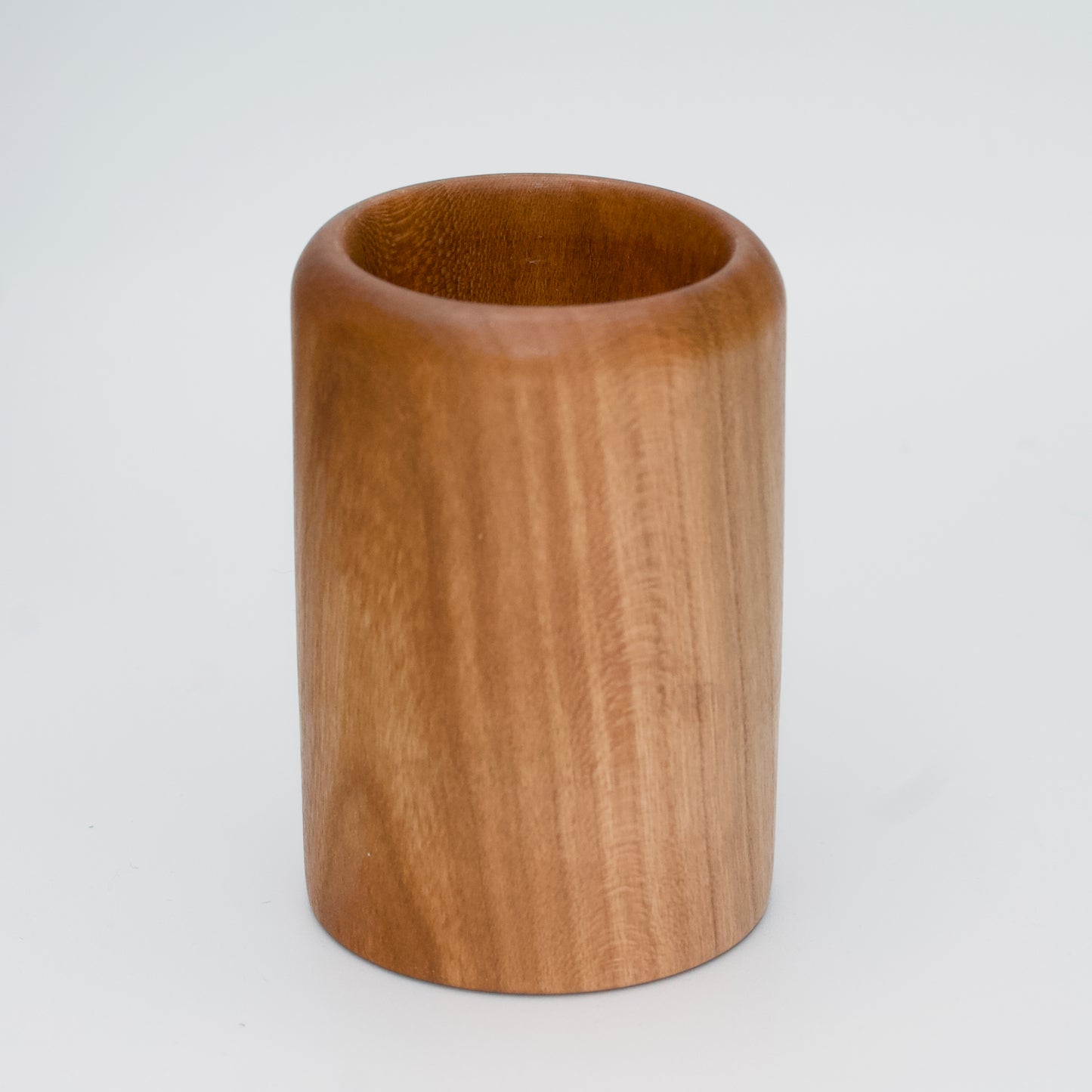 Cherry wood shot glass against white background