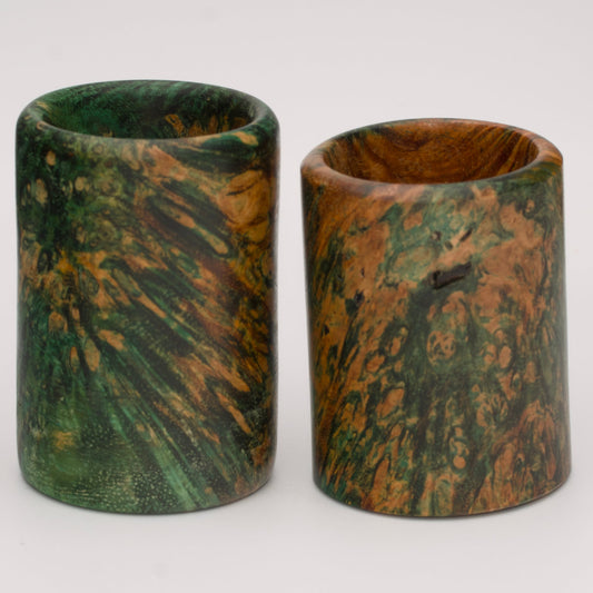 Pair of dyed green river tamarind burl shot glasses against white background