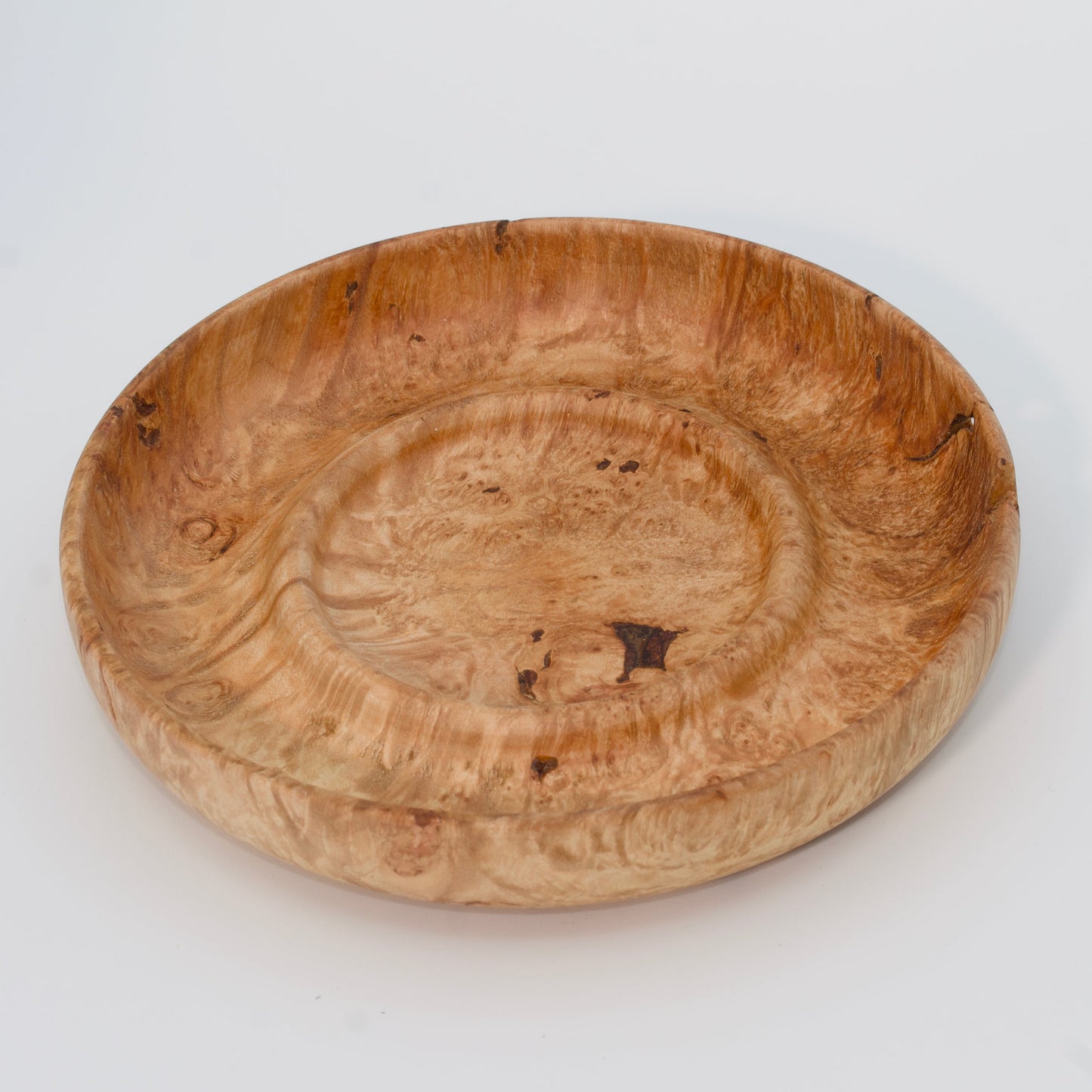 Decorative wooden plate from big leaf maple burl on a white background