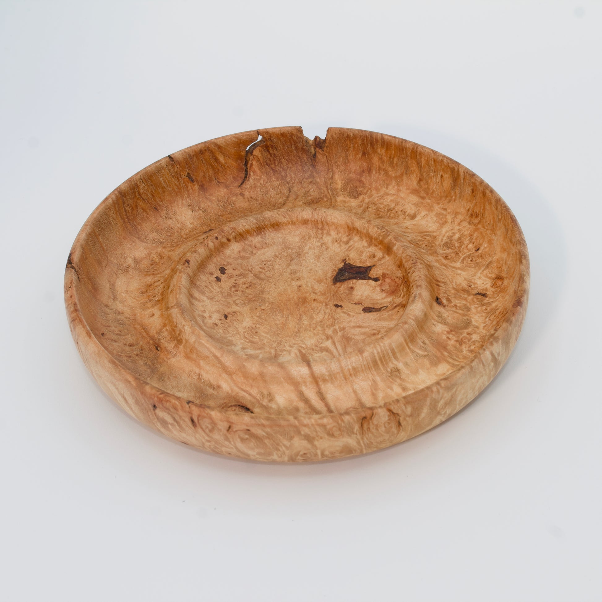 Decorative wooden plate from big leaf maple burl on a white background