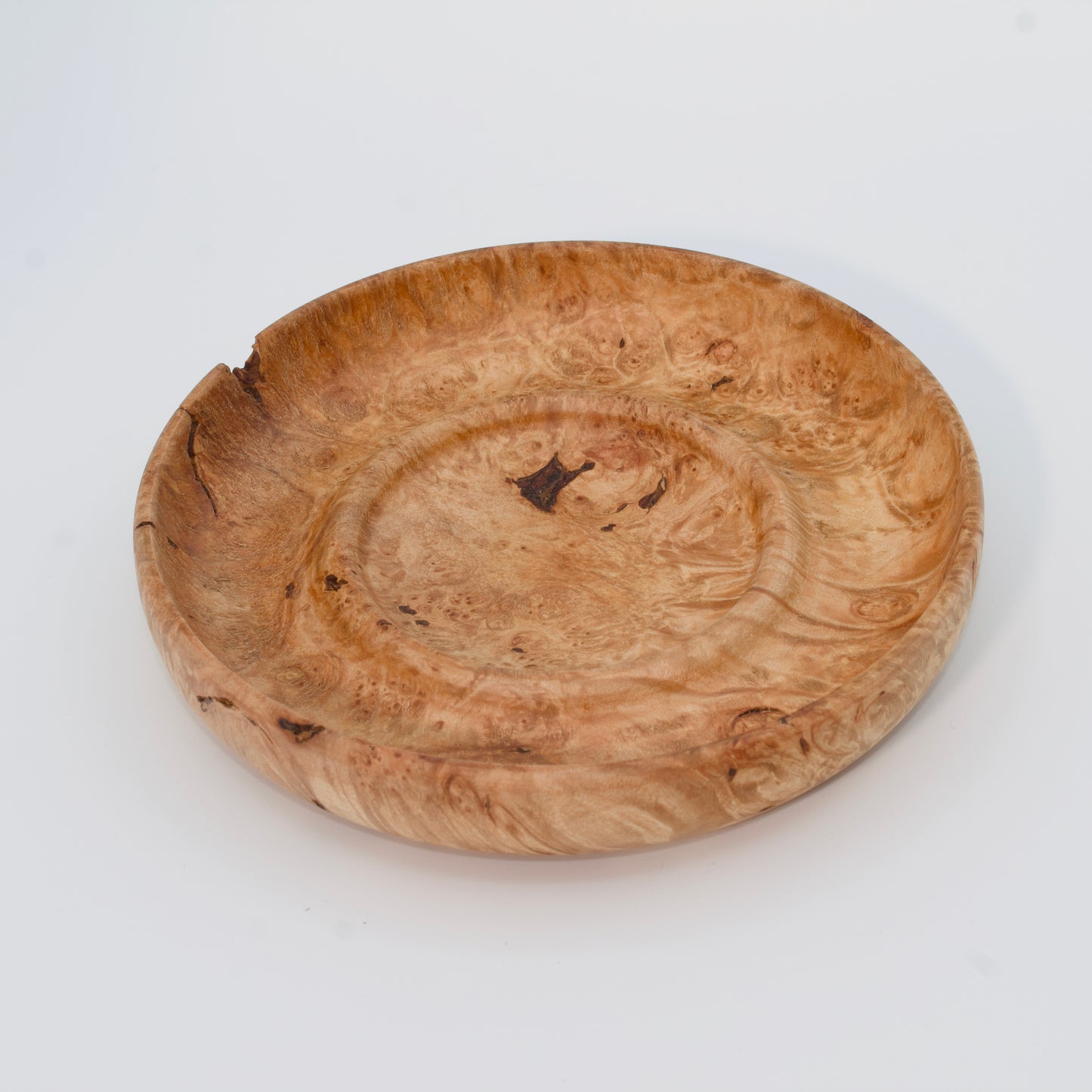 Decorative wooden plate from big leaf maple burl on a white background