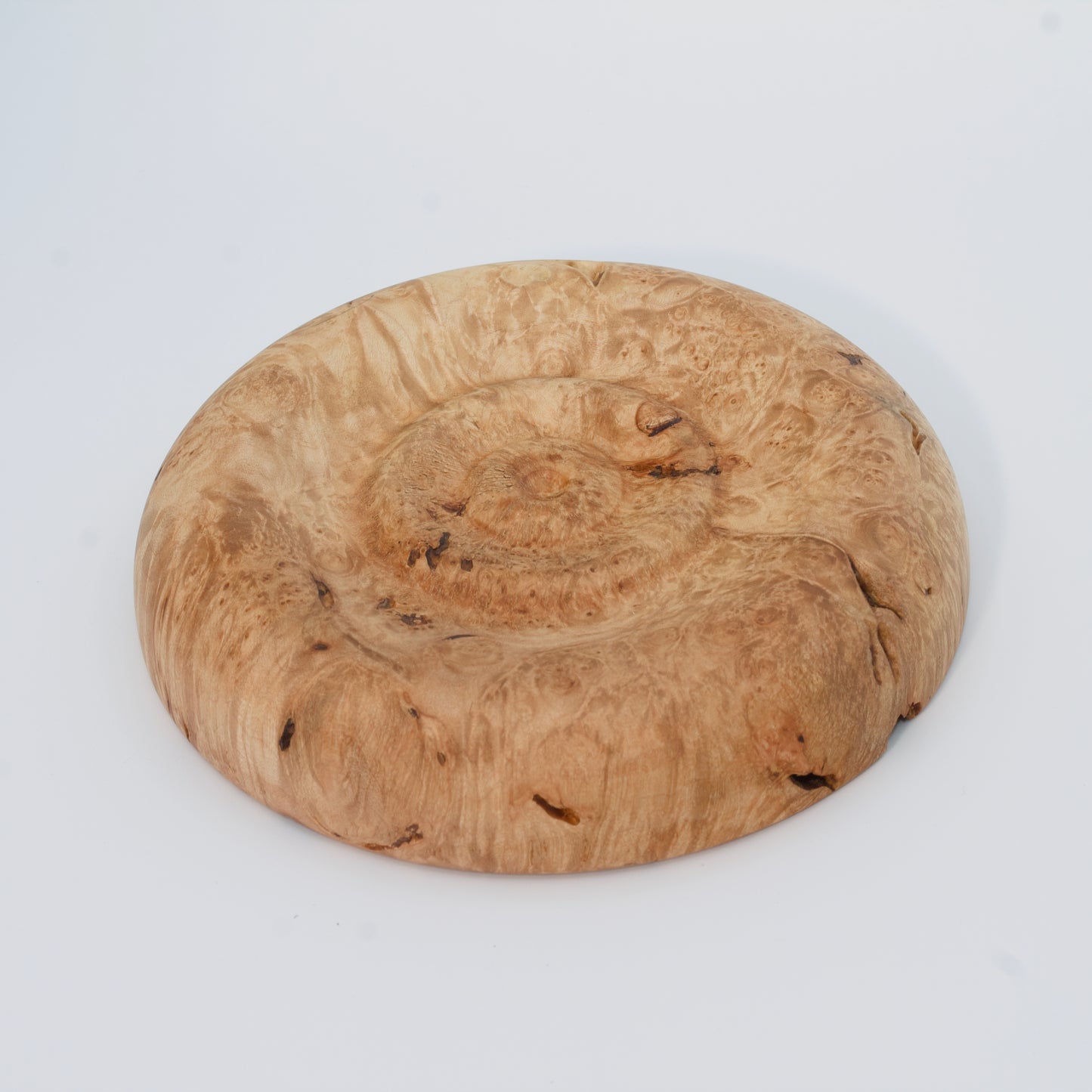 Decorative wooden plate from big leaf maple burl on a white background