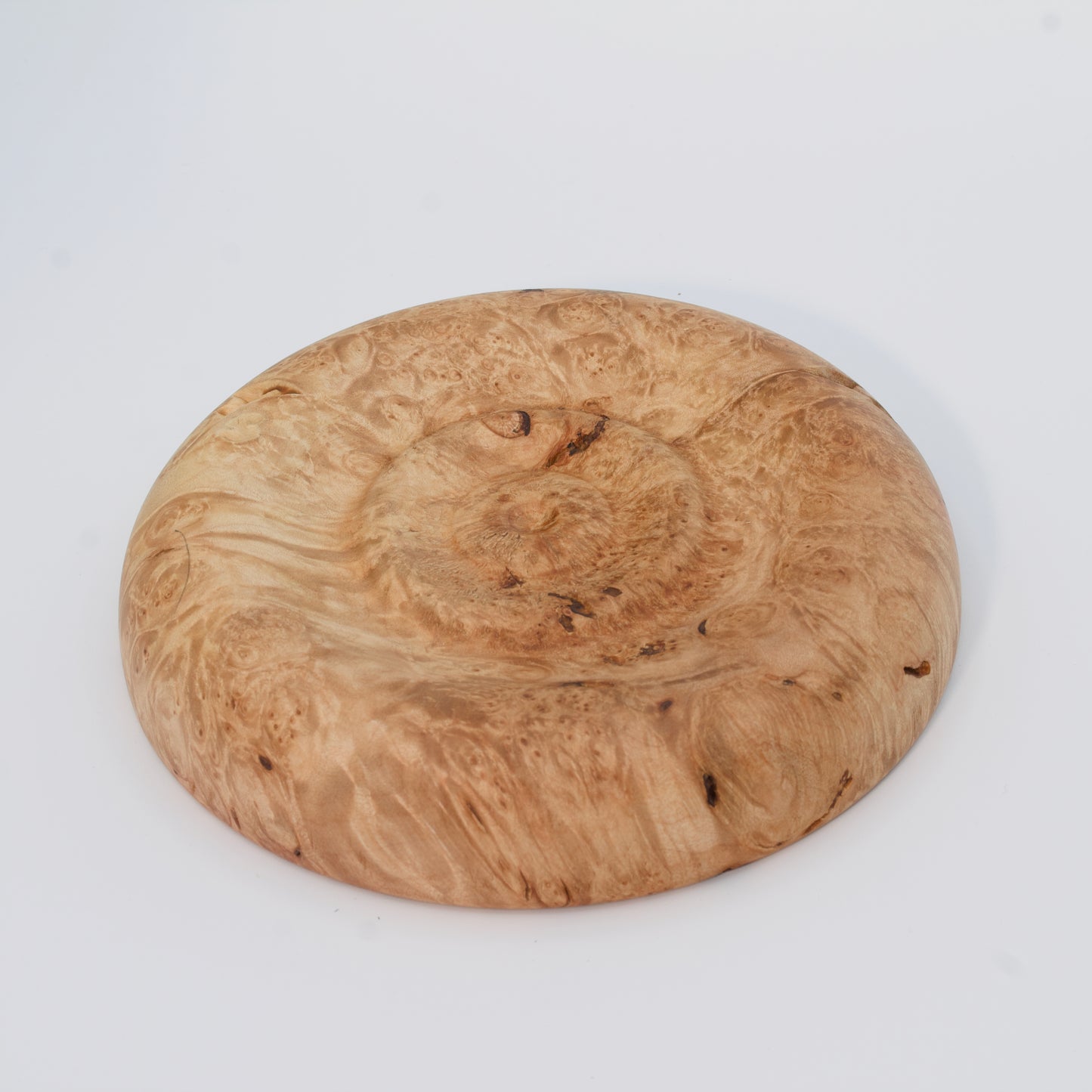 Decorative wooden plate from big leaf maple burl on a white background