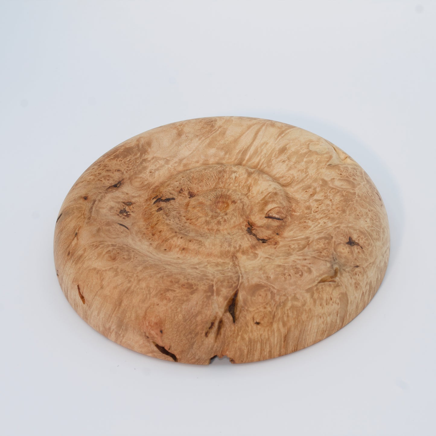Decorative wooden plate from big leaf maple burl on a white background