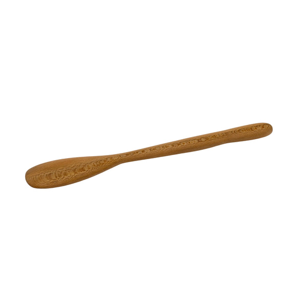 Wooden spoon with intricate carvings on a beige background