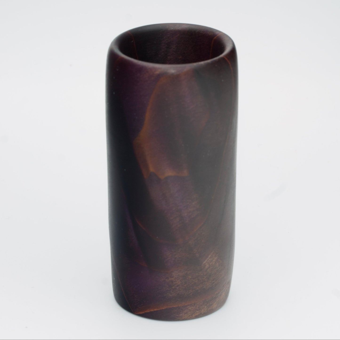 Violet colored wood shot glass against white background