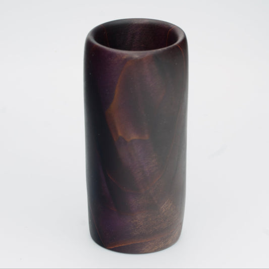 Violet colored wood shot glass against white background