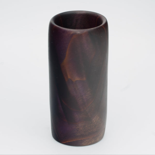 Violet colored wood shot glass against white background