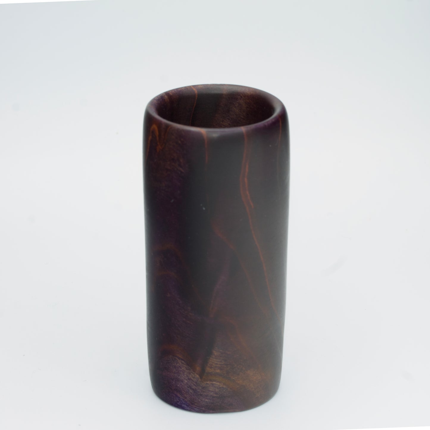 Violet colored wood shot glass against white background