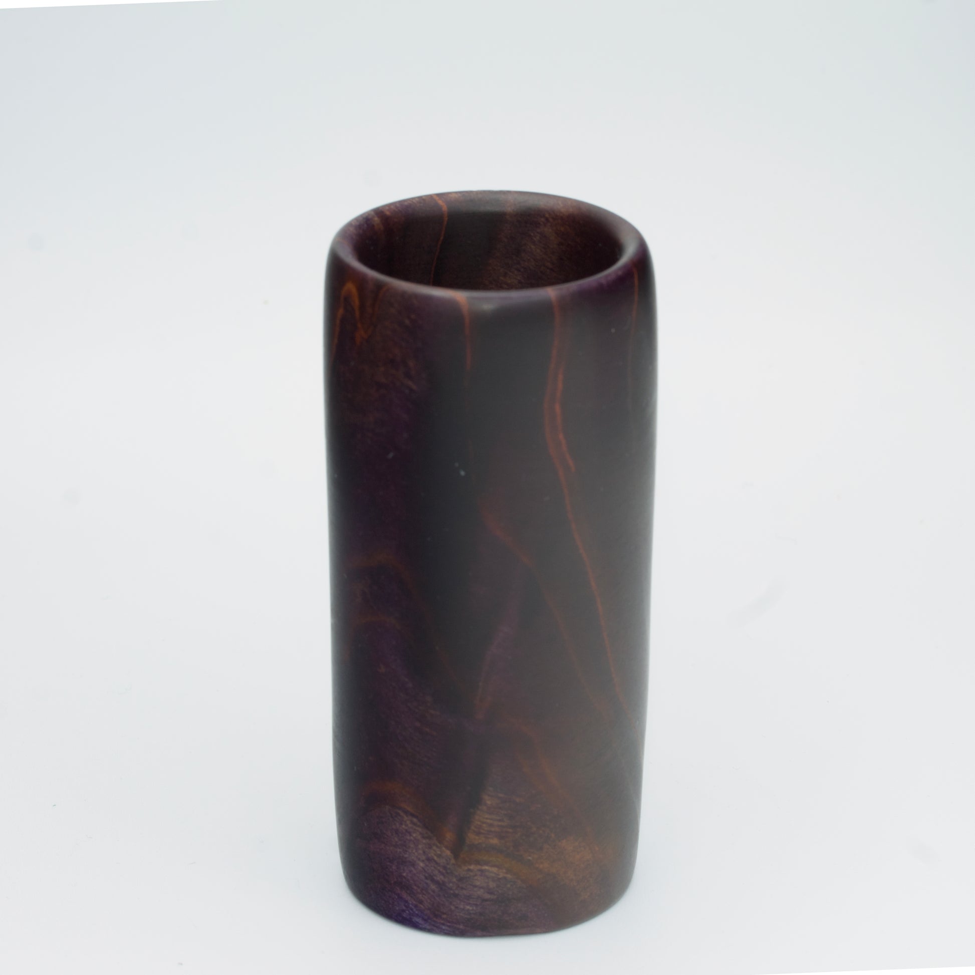 Violet colored wood shot glass against white background