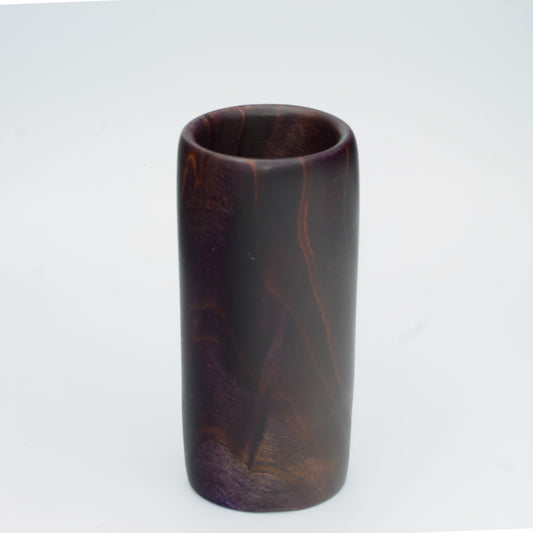 Violet colored wood shot glass against white background