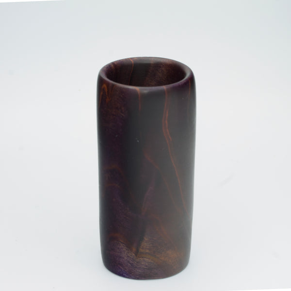 Violet colored wood shot glass against white background