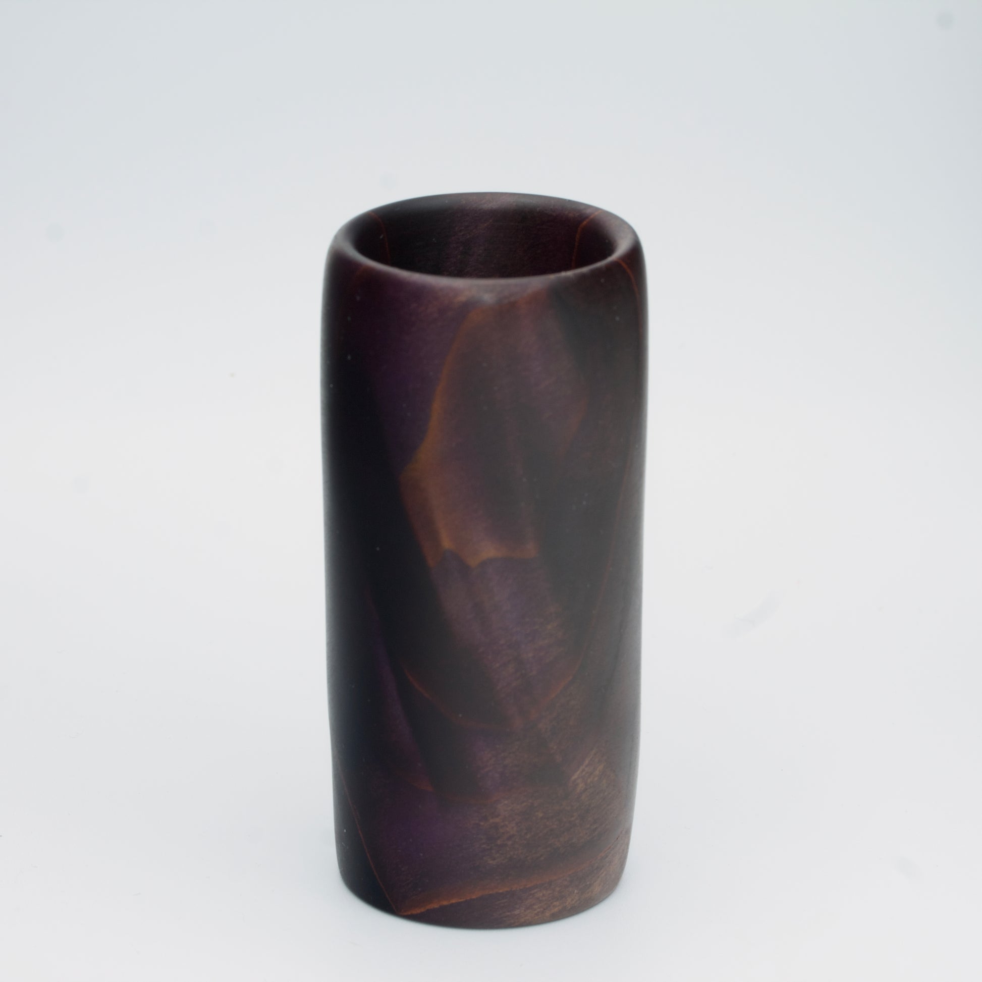 Violet colored wood shot glass against white background