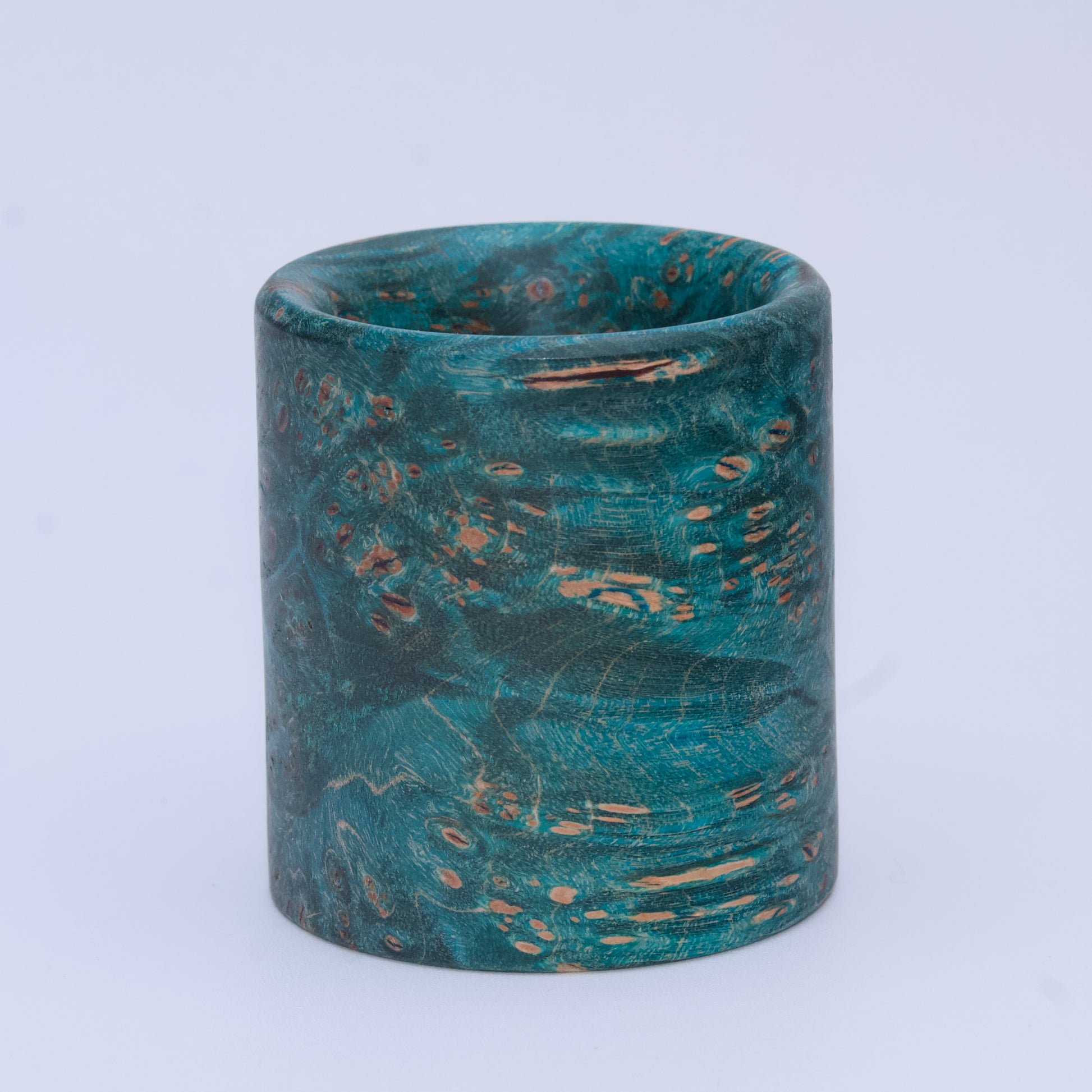 Blue  maple burl wood shot glass against white background