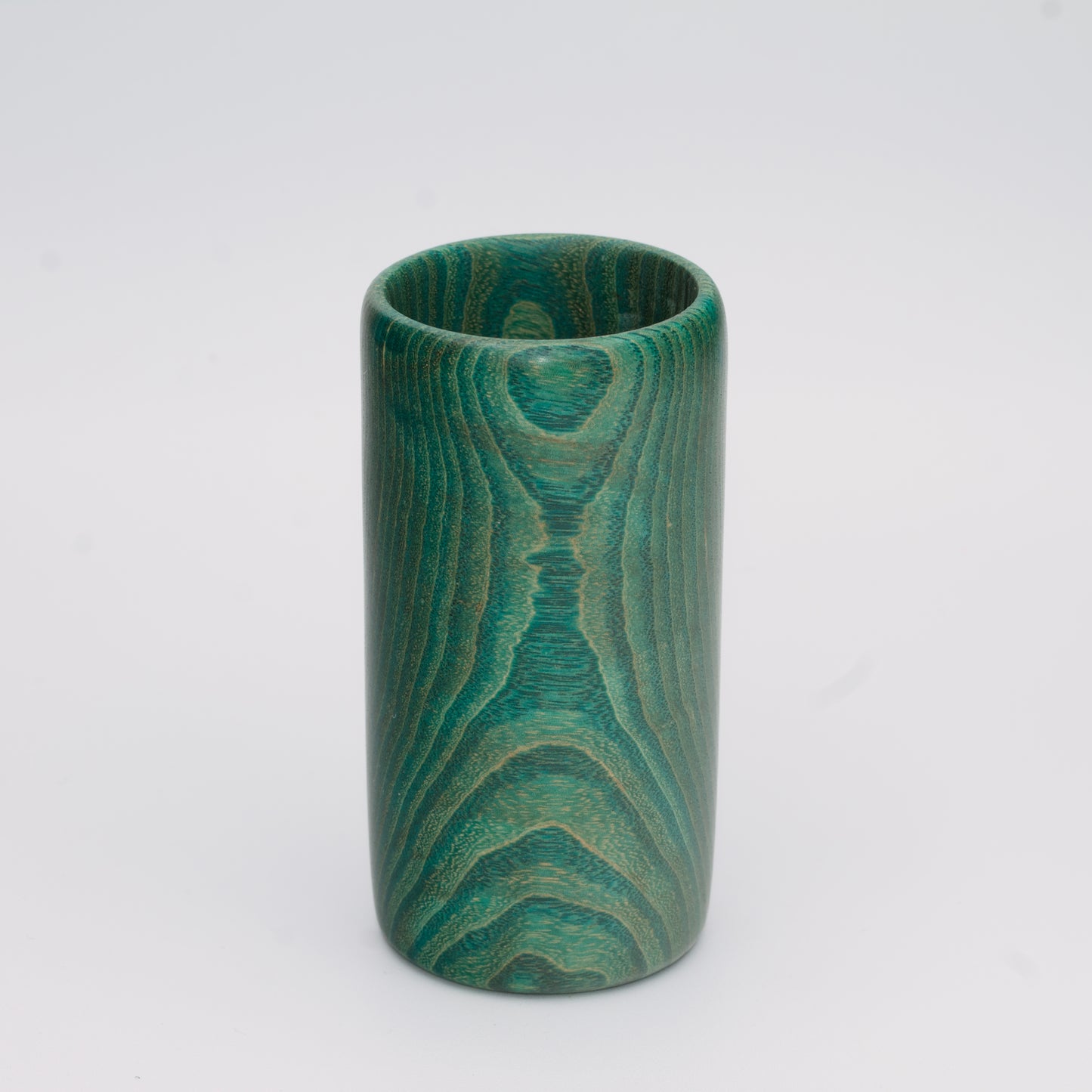 Green dyed oak wood shot glass against white background