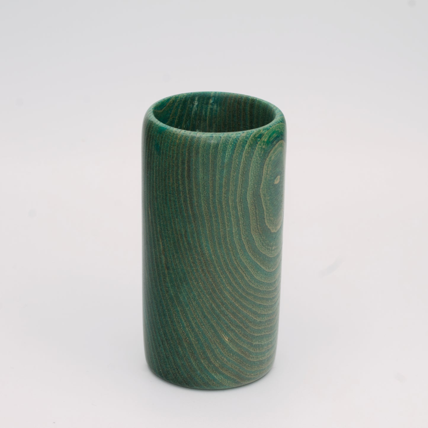 Green dyed oak wood shot glass against white background
