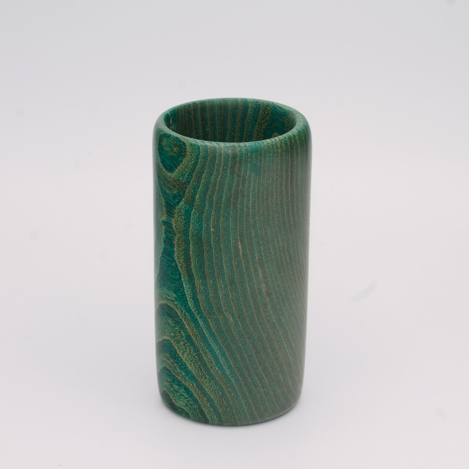 Green dyed oak wood shot glass against white background