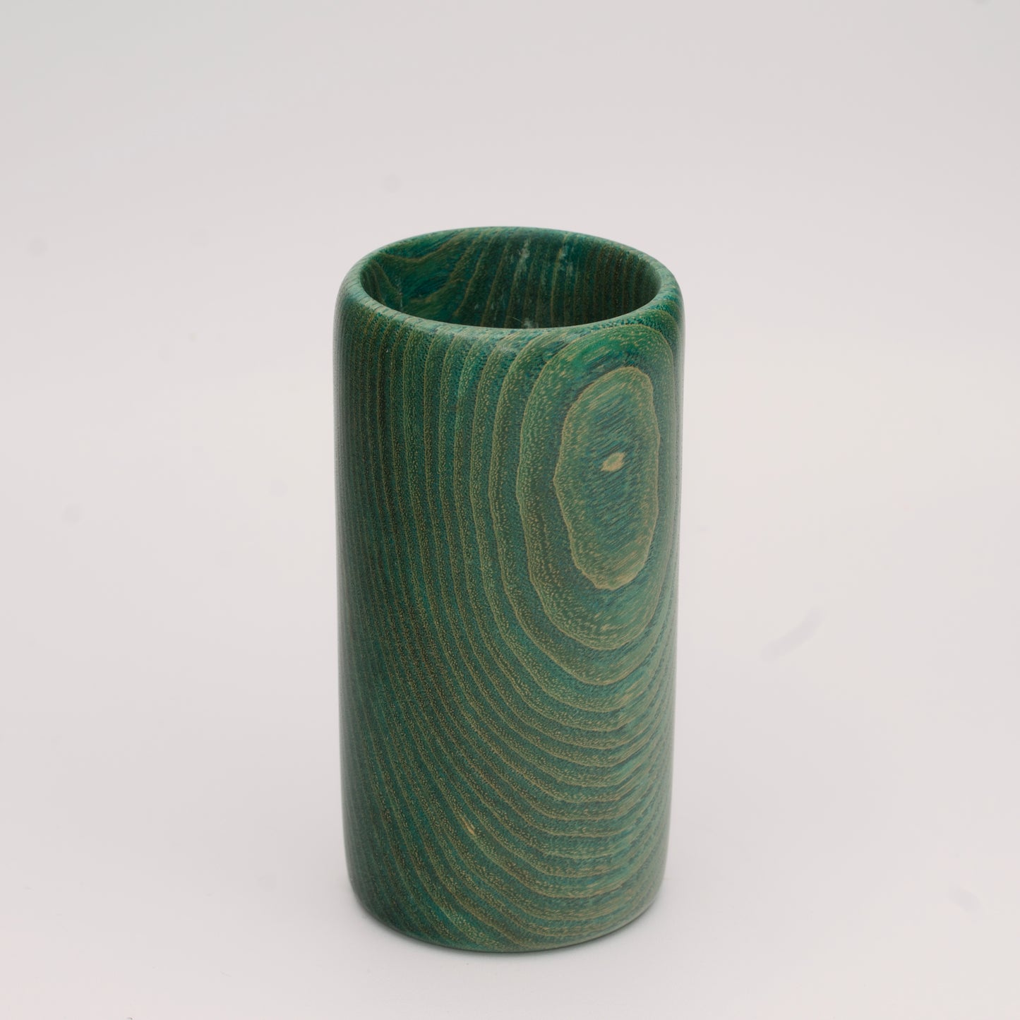 Green dyed oak wood shot glass against white background