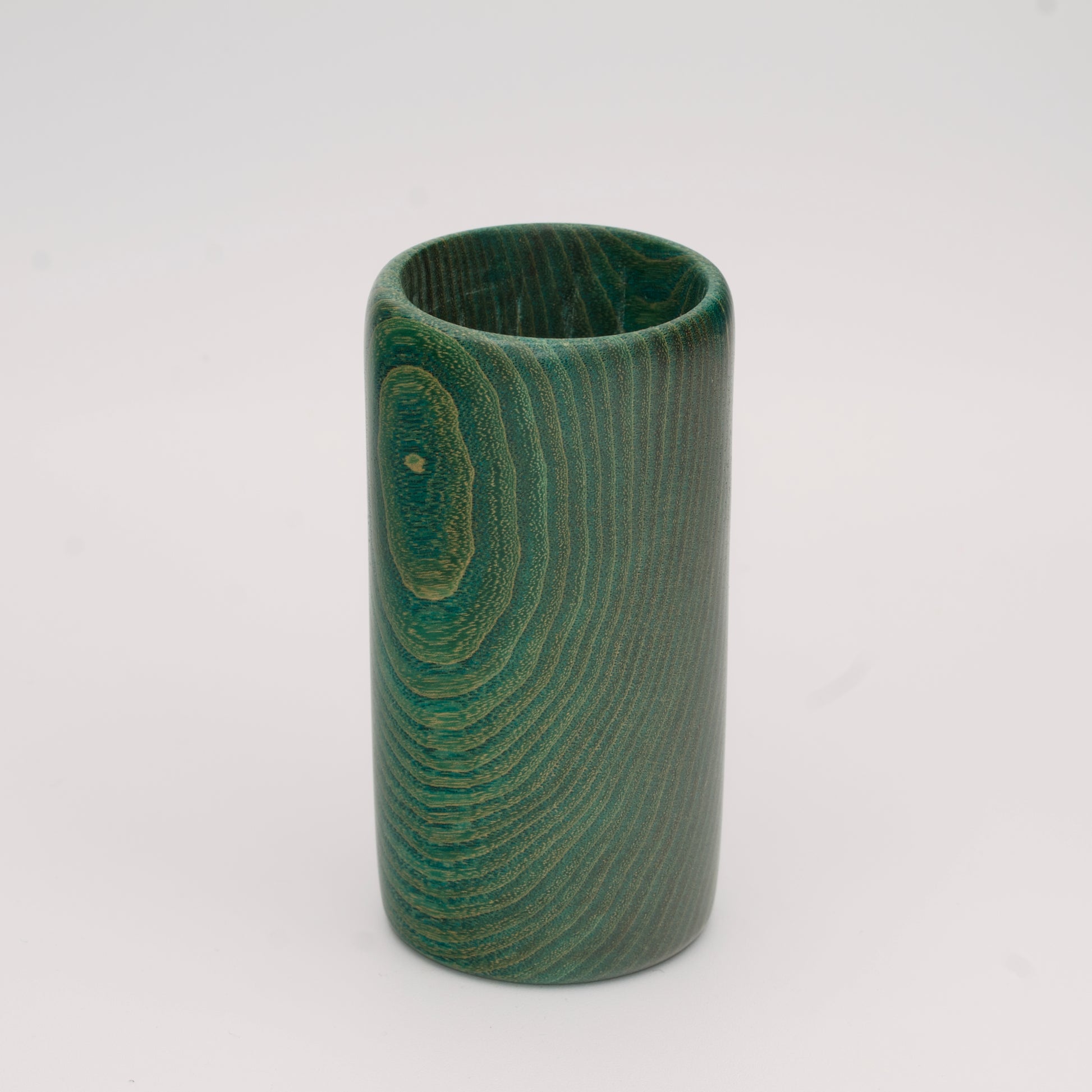 Green dyed oak wood shot glass against white background