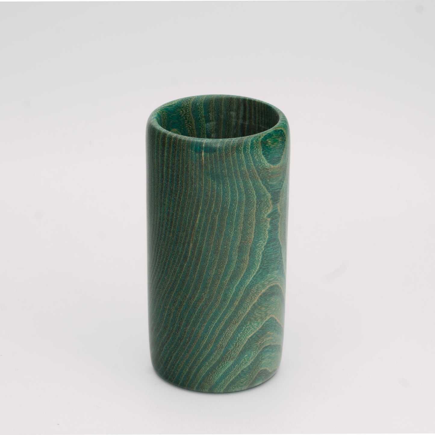 Green dyed oak wood shot glass against white background