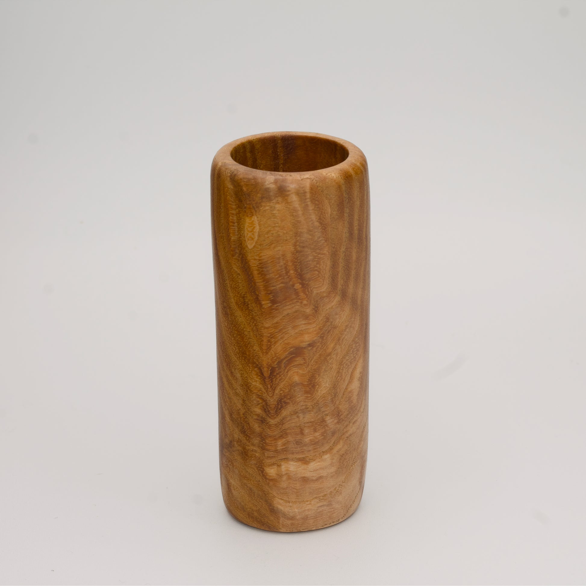 Figured Ash wood shot glass against white background