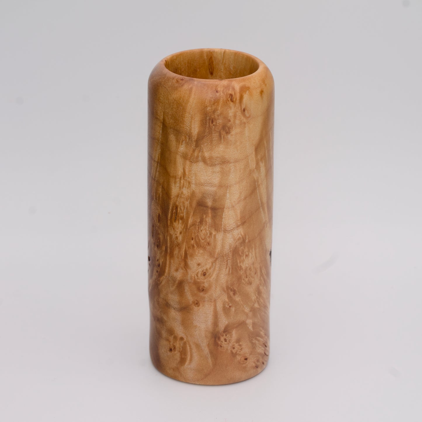 Figured maple wood shot glass against white background
