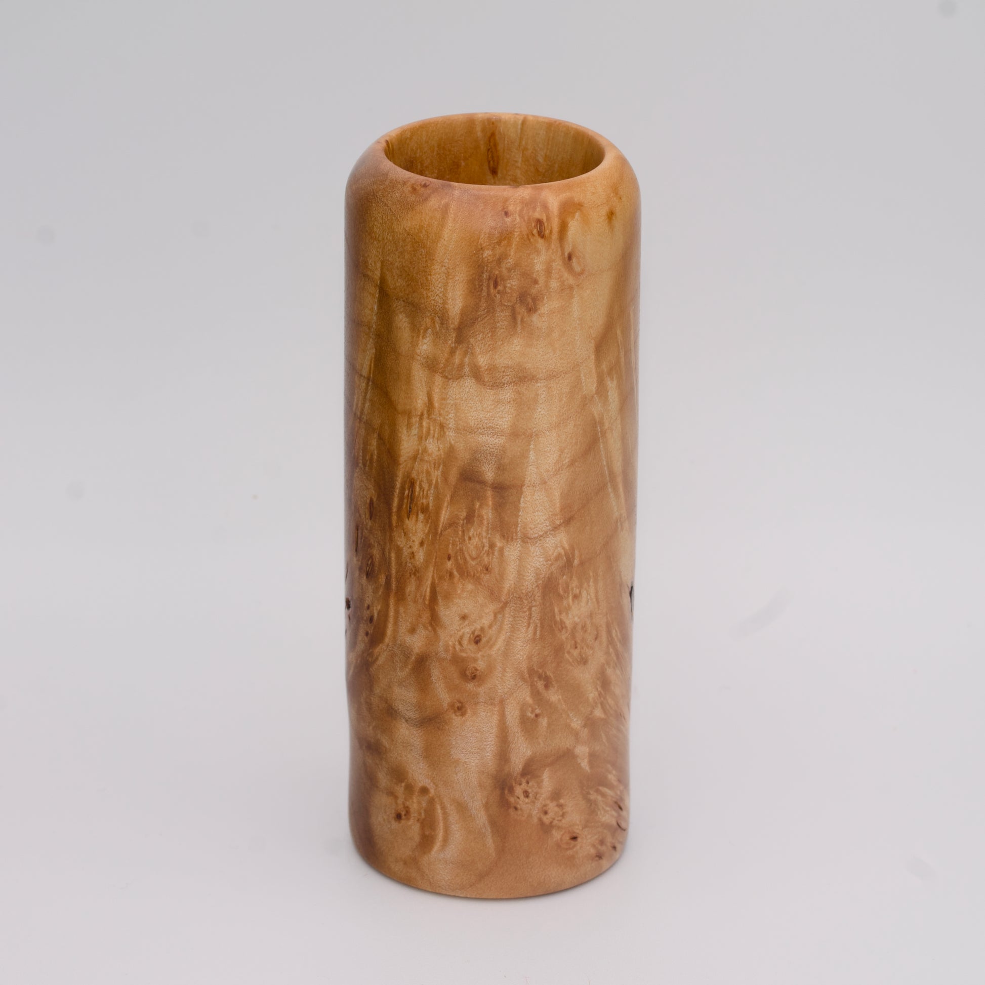 Figured maple wood shot glass against white background