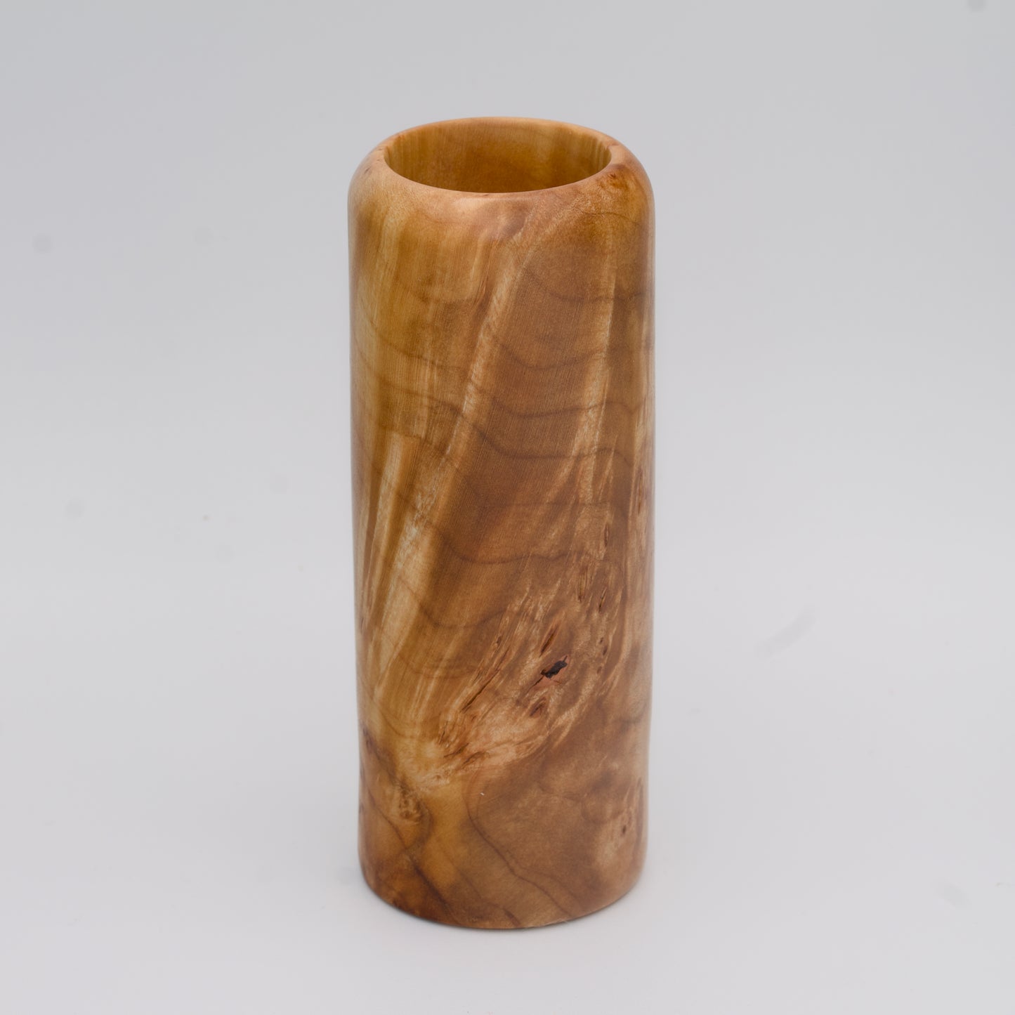 Figured maple wood shot glass against white background