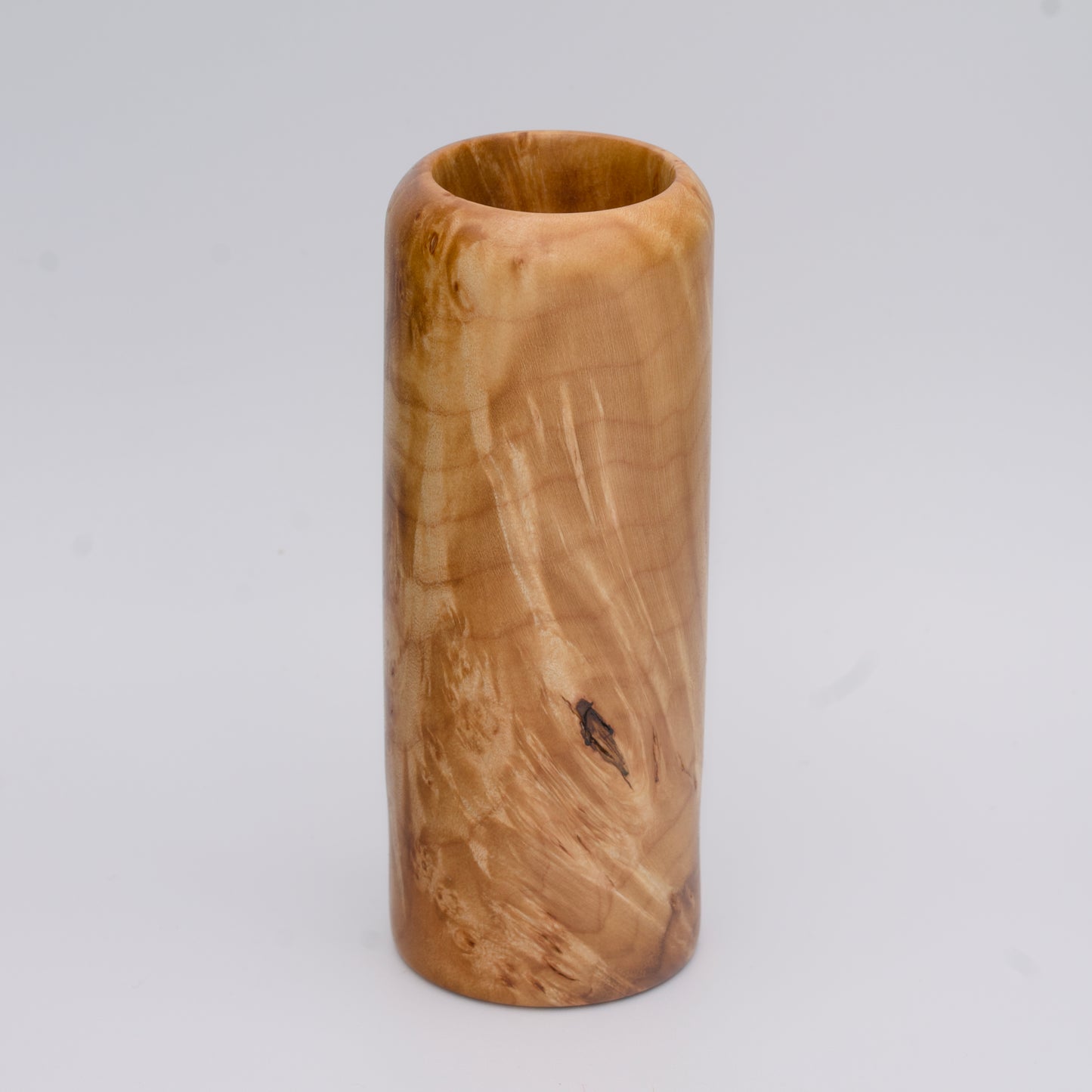 Figured maple wood shot glass against white background
