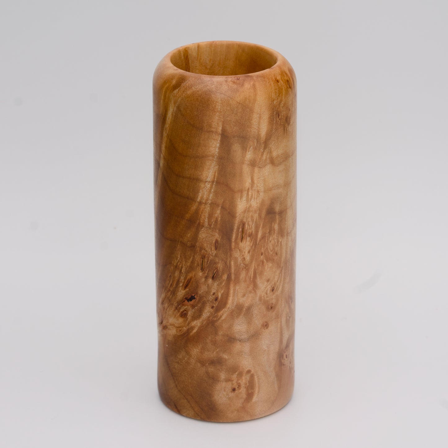 Figured maple wood shot glass against white background