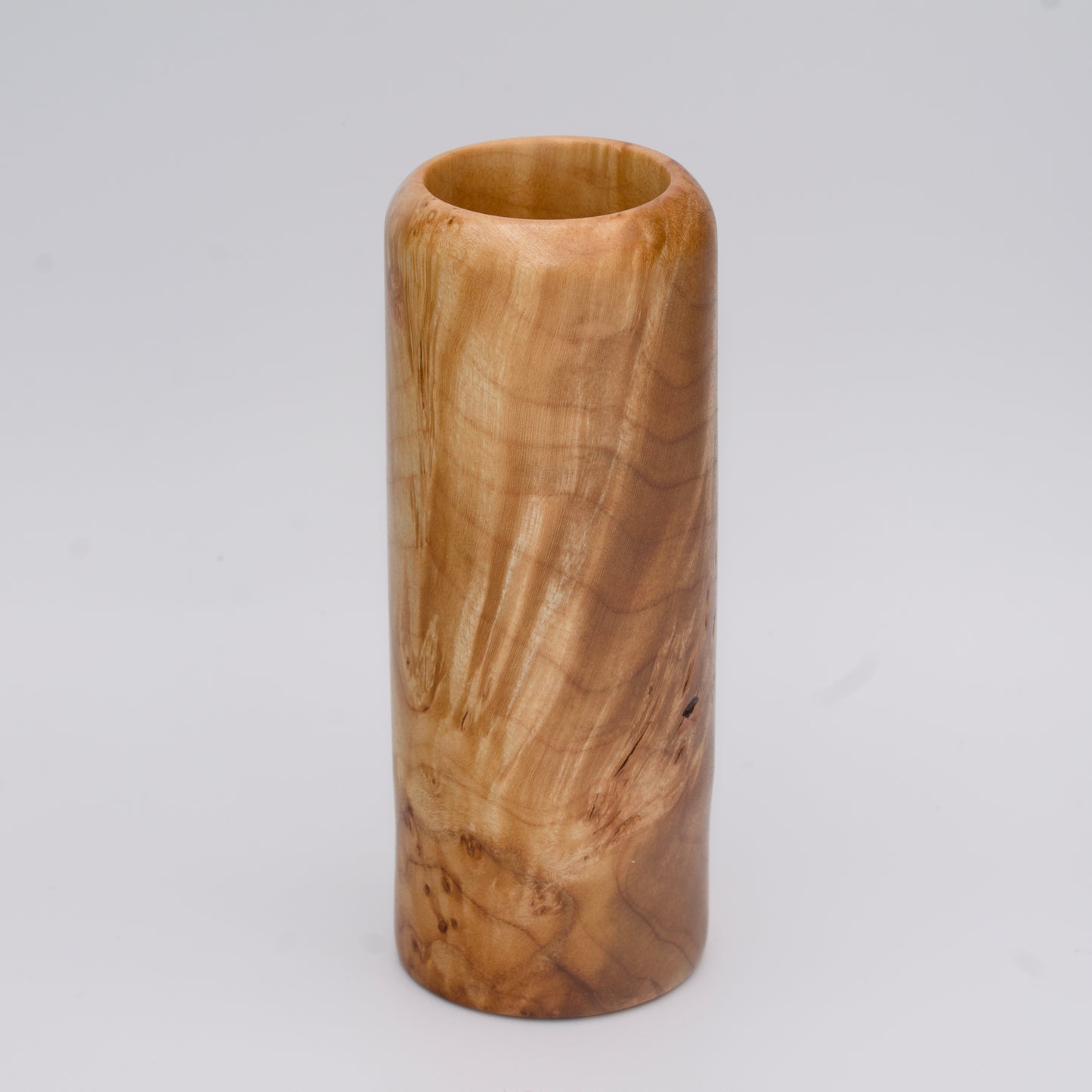 Figured maple wood shot glass against white background