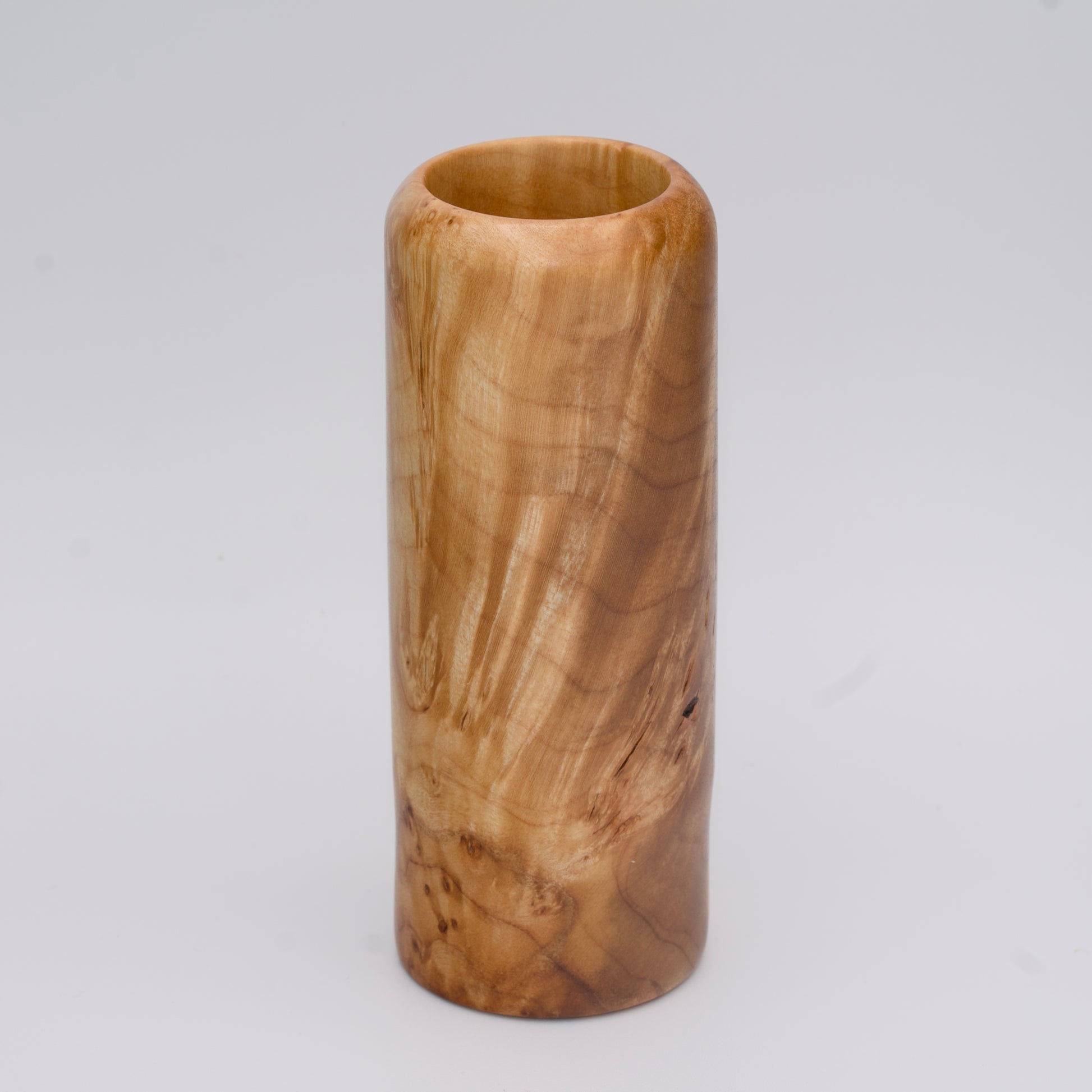 Figured maple wood shot glass against white background