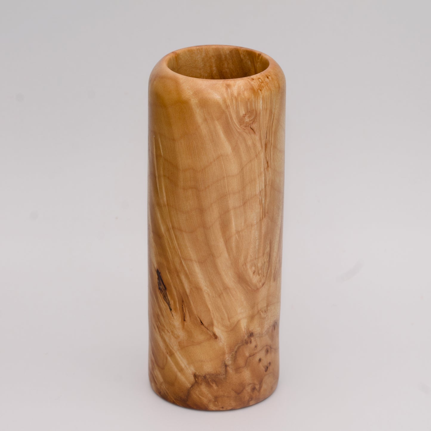 Figured maple wood shot glass against white background